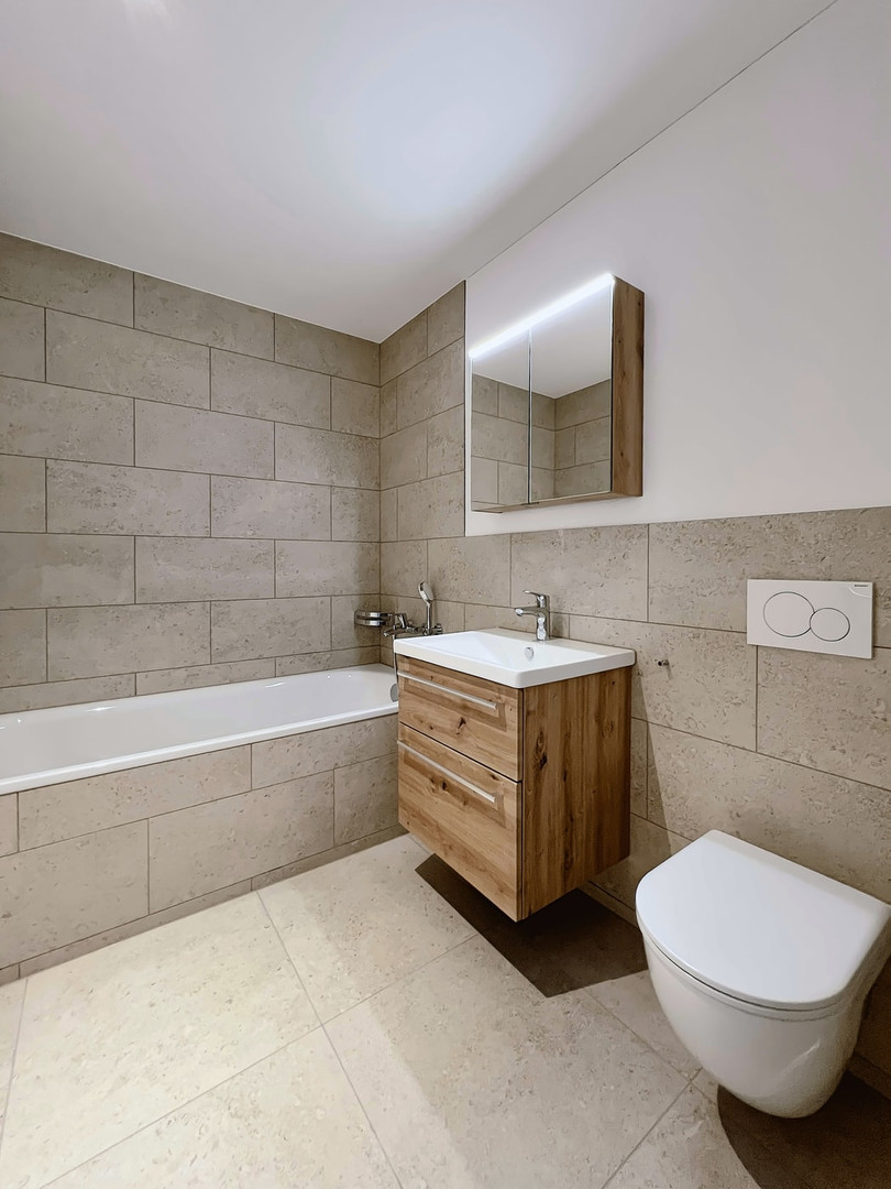 Modernes Badezimmer mit Badewanne, Waschtisch und wandhängendem WC