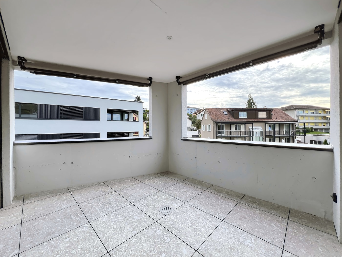 Überdachter Balkon mit Blick auf Wohngebäude