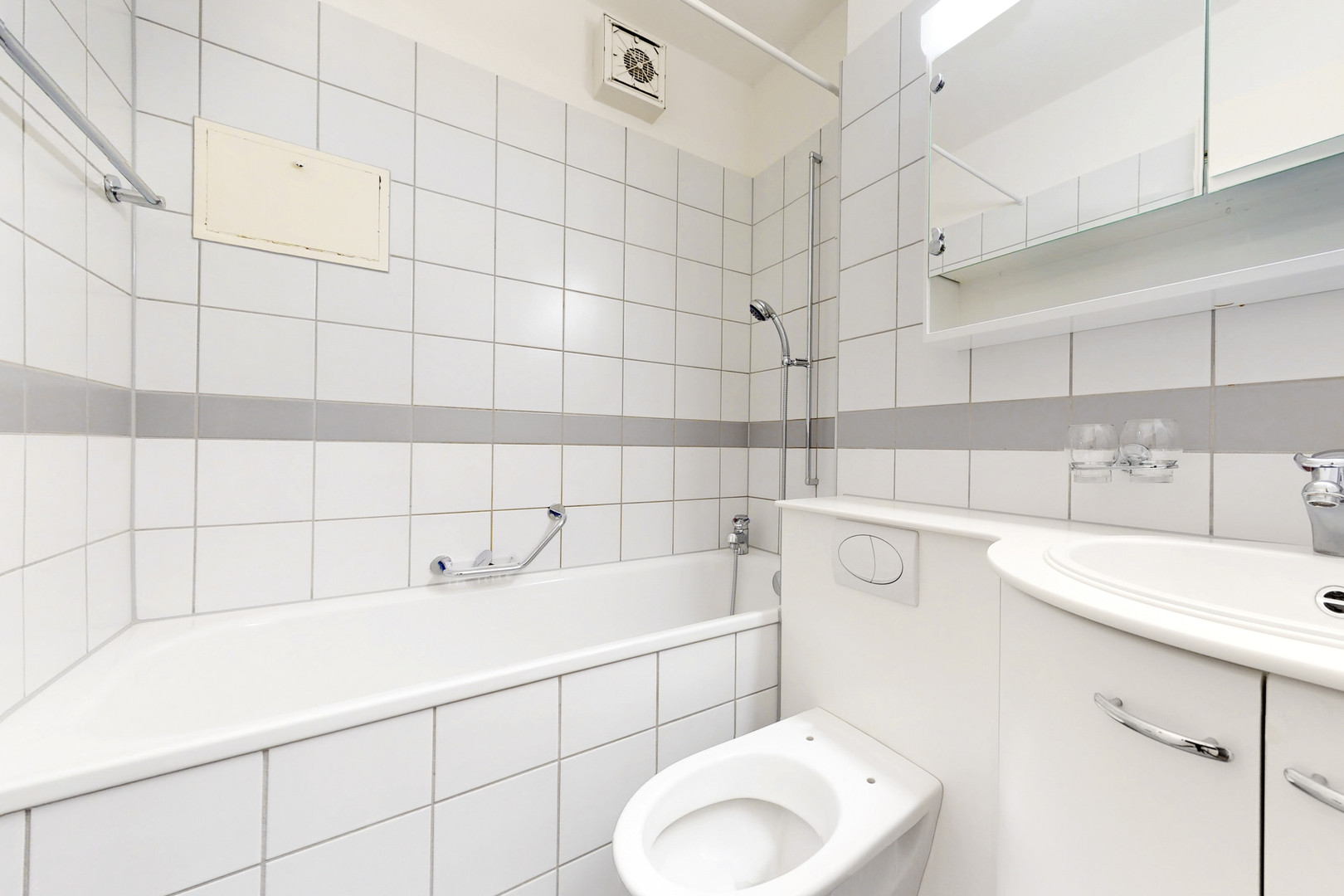 Kleines weiß gefliestes Badezimmer