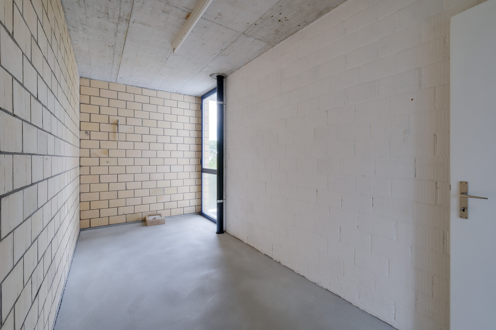 Unfertiger Innenraum mit Beton, Mauerwerk und Fenster