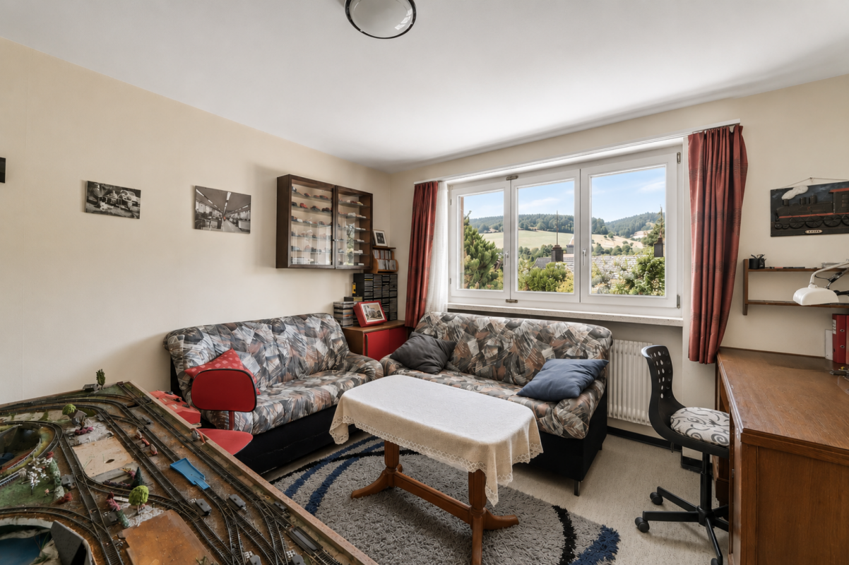 Gemütliches Wohnzimmer mit großem Fenster und Landschaftsblick