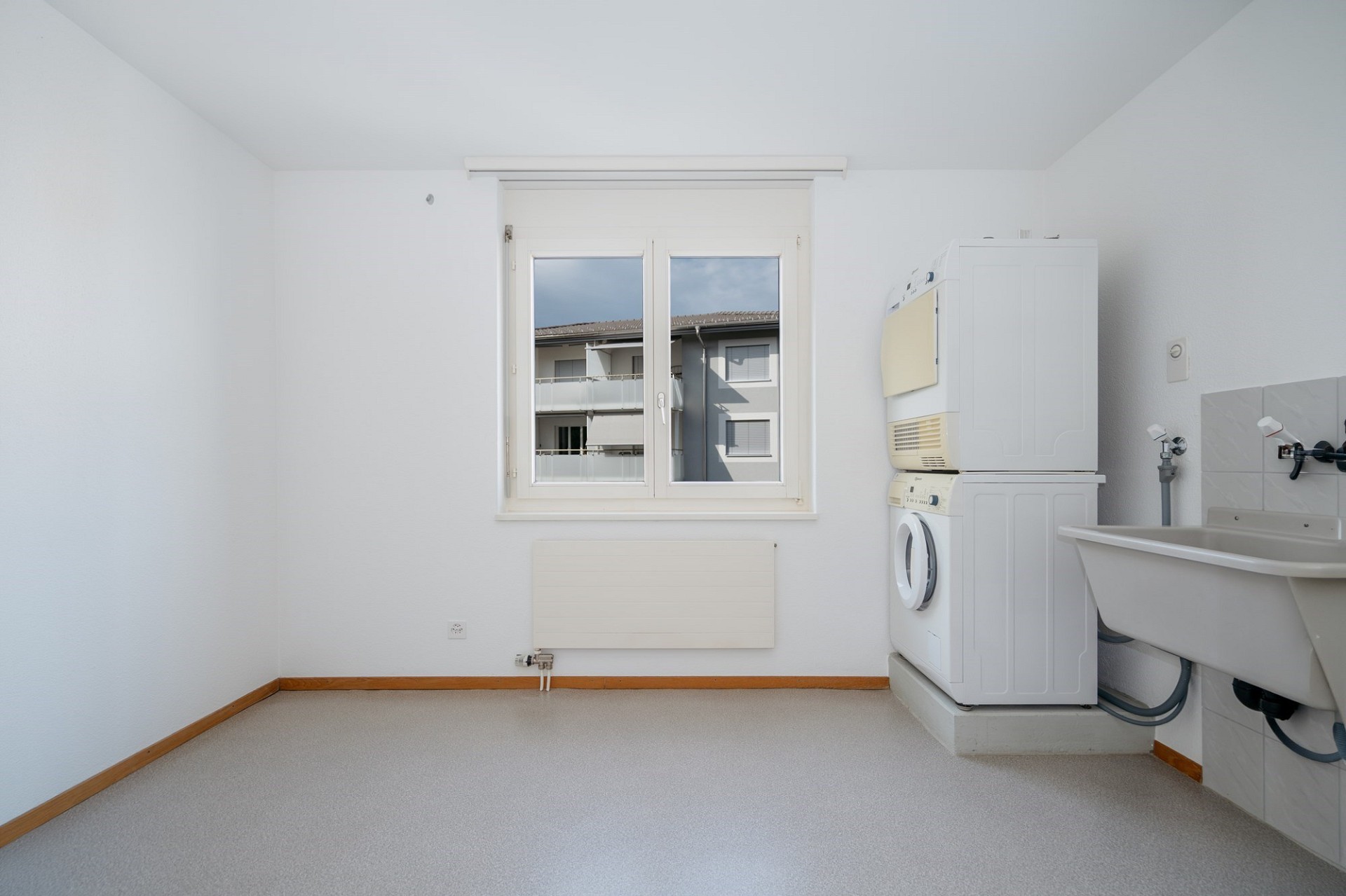 Hauswirtschaftsraum mit Fenster, Waschmaschine und Waschbecken