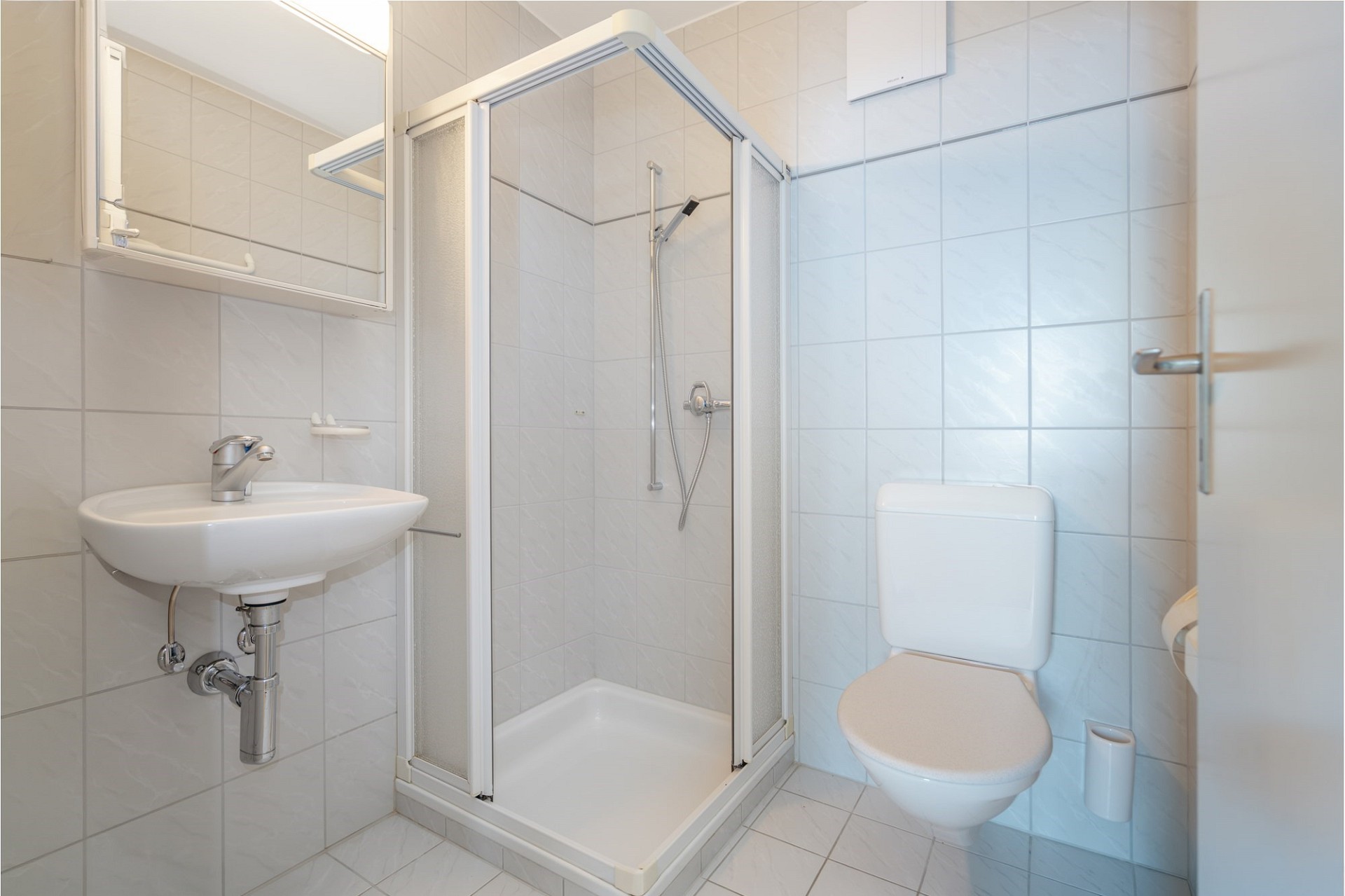 Kleines helles Badezimmer mit Dusche und WC