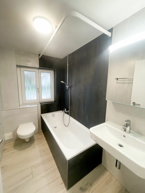 Modernes Badezimmer mit Badewanne und Wand-WC