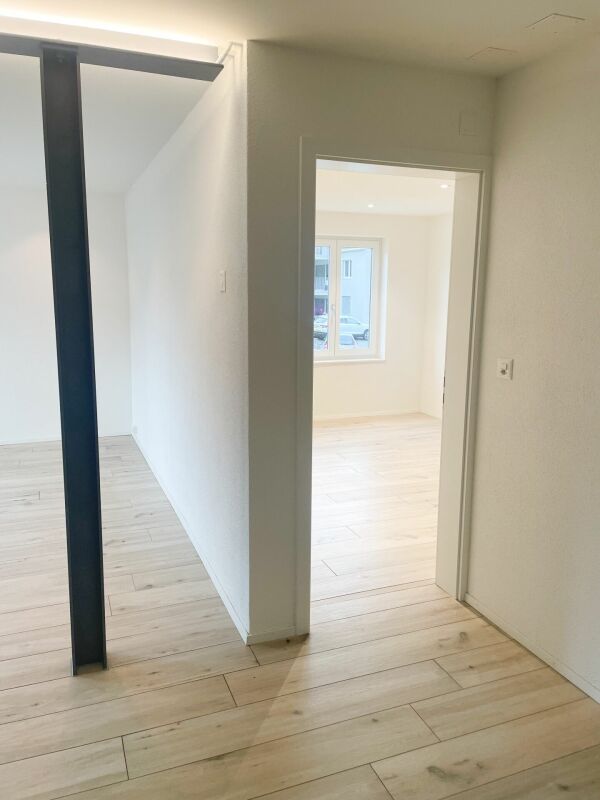 Heller Flur mit Blick in einen Nebenraum