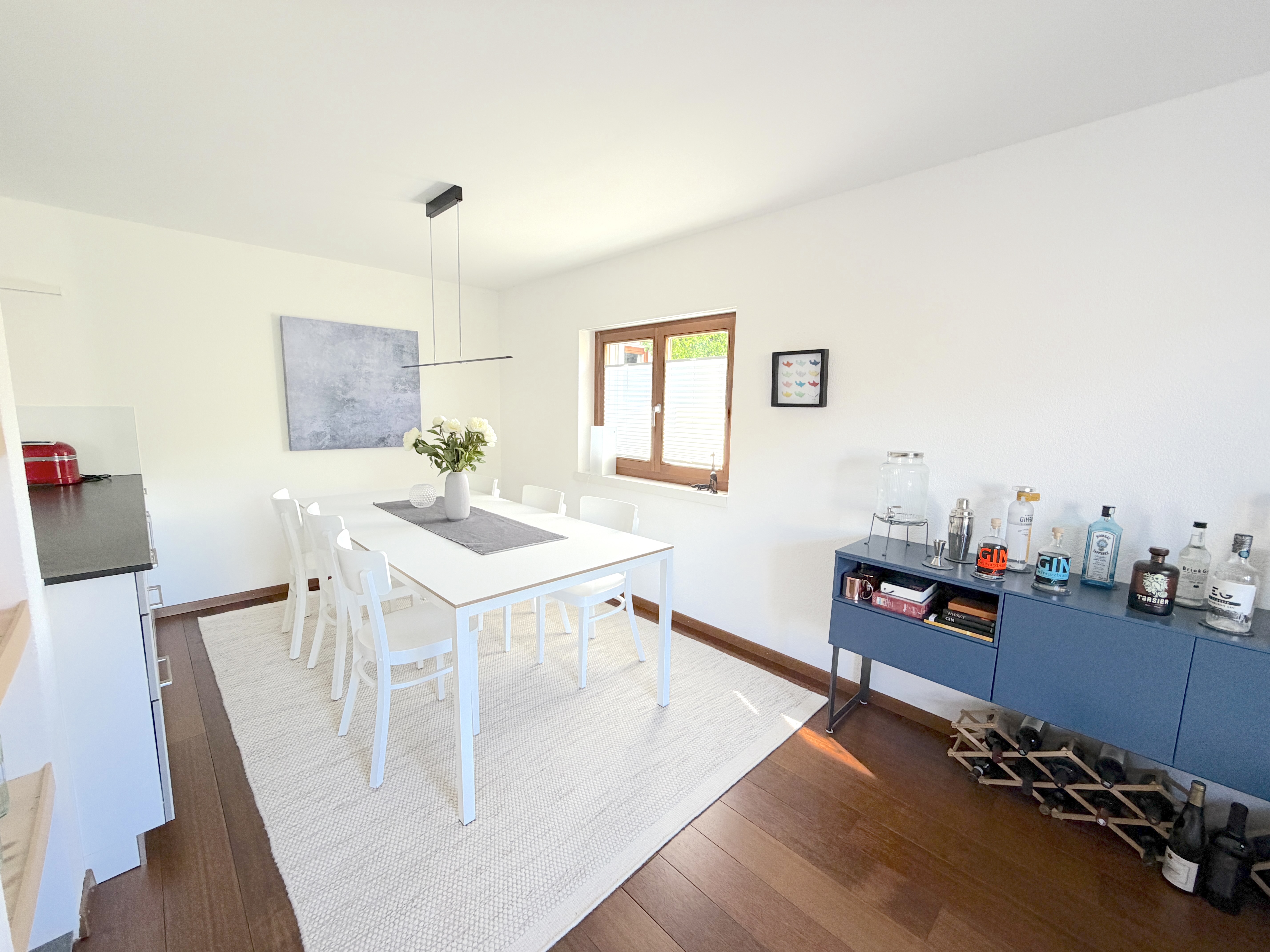 Esszimmer mit weißem Interieur und Holzboden