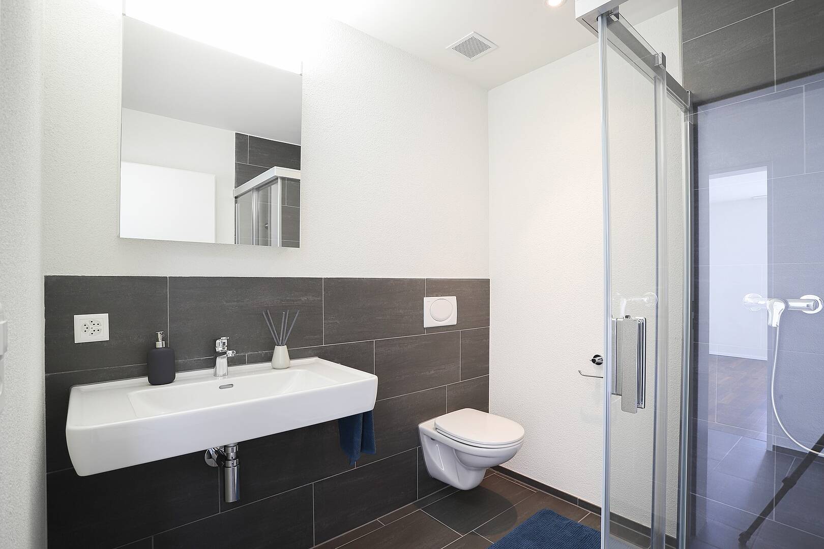 Modernes Badezimmer mit Dusche und wandhängendem WC
