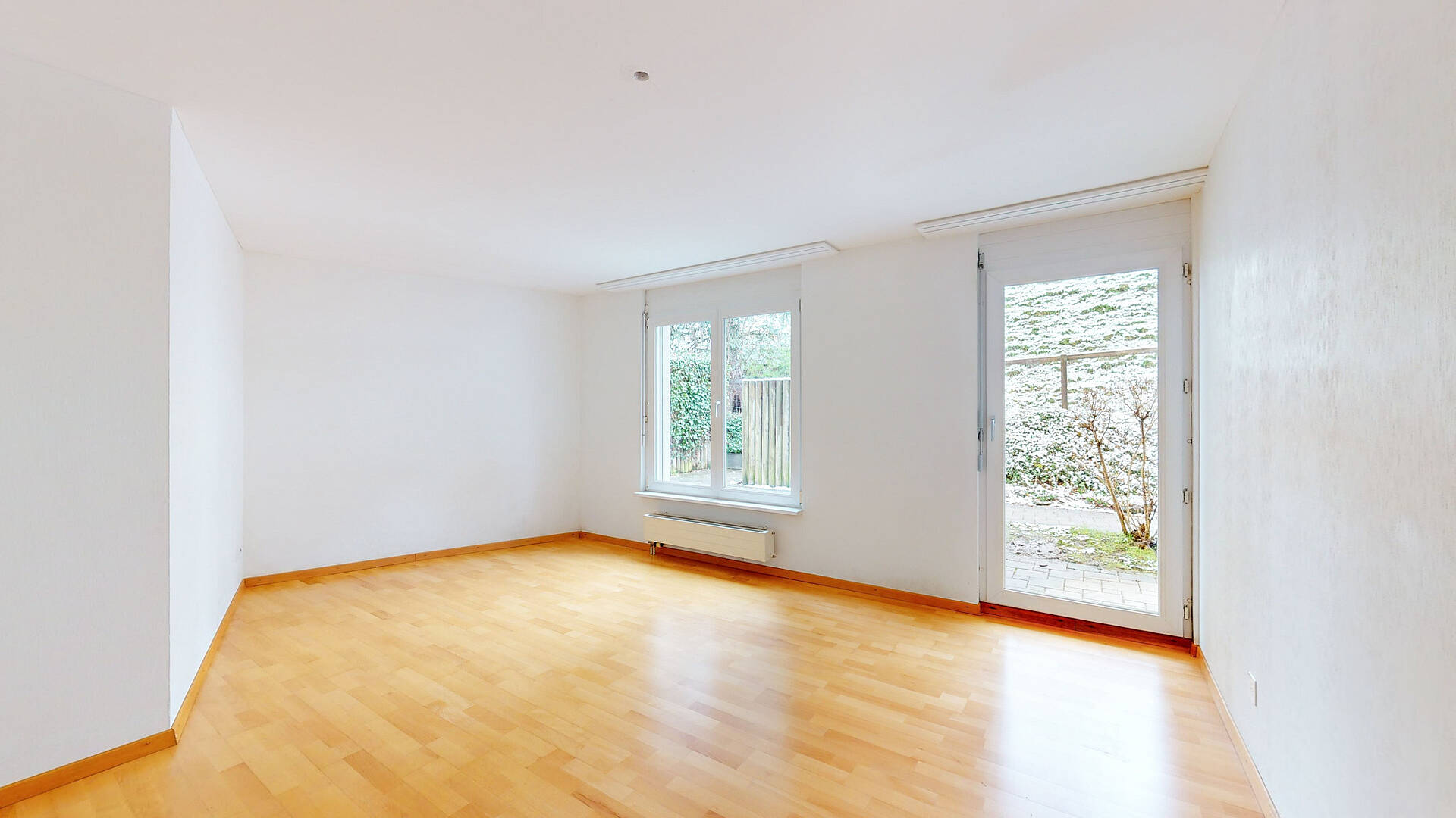 Heller leerer Raum mit Parkett und Fenstertür