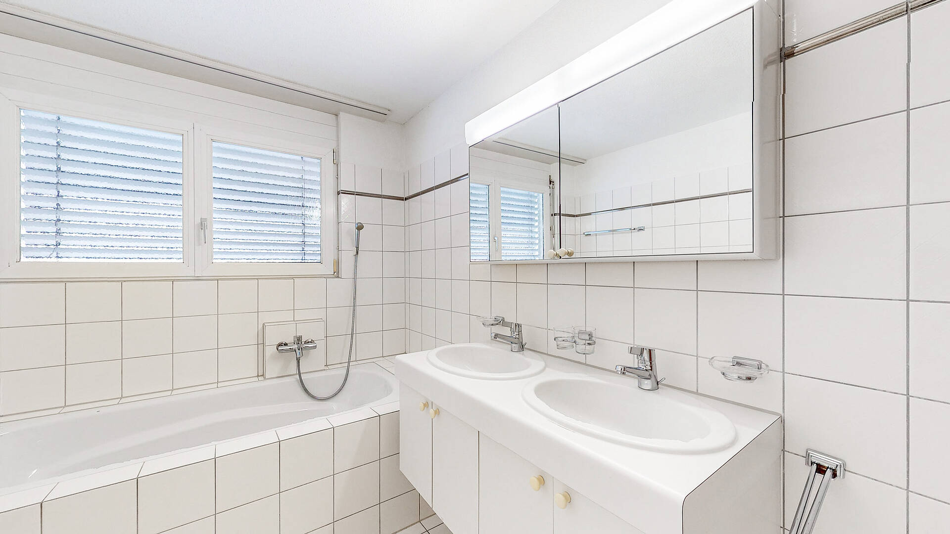 Helles Badezimmer mit Doppelwaschtisch und Badewanne