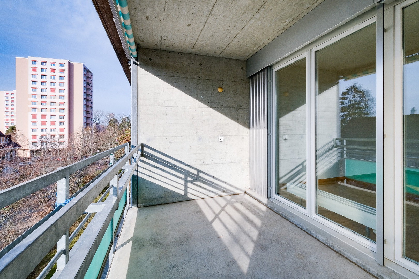 Balkon mit Betonwänden und Glasgeländer