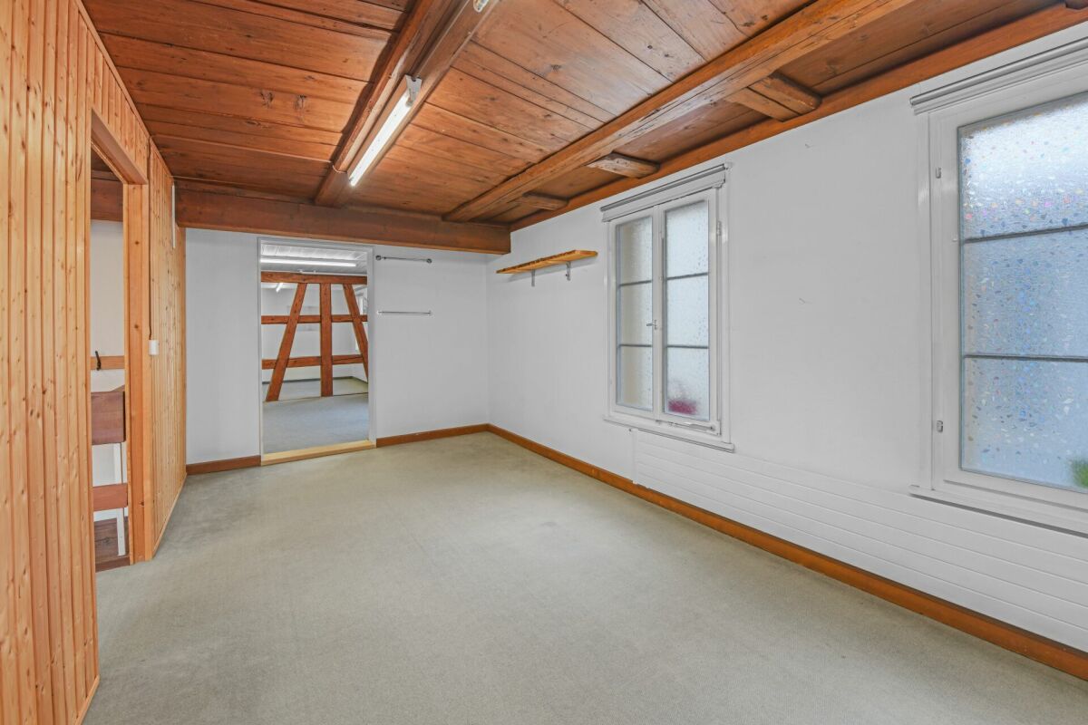 Ausgebauter Dachraum mit Holzbalken und schlichter Ausstattung