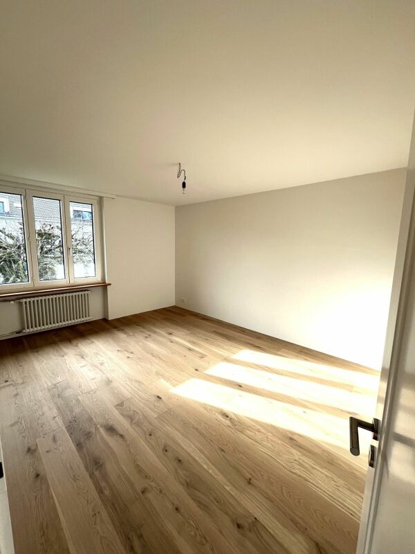 Leerer, heller Wohnraum mit Holzfußboden