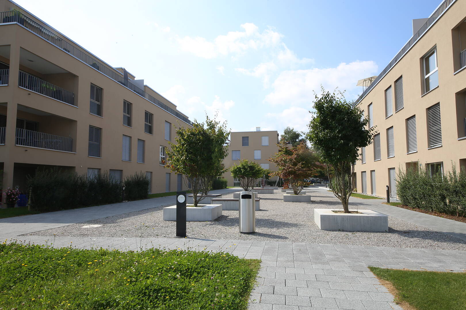 Moderner Wohnhof zwischen Mehrfamilienhäusern