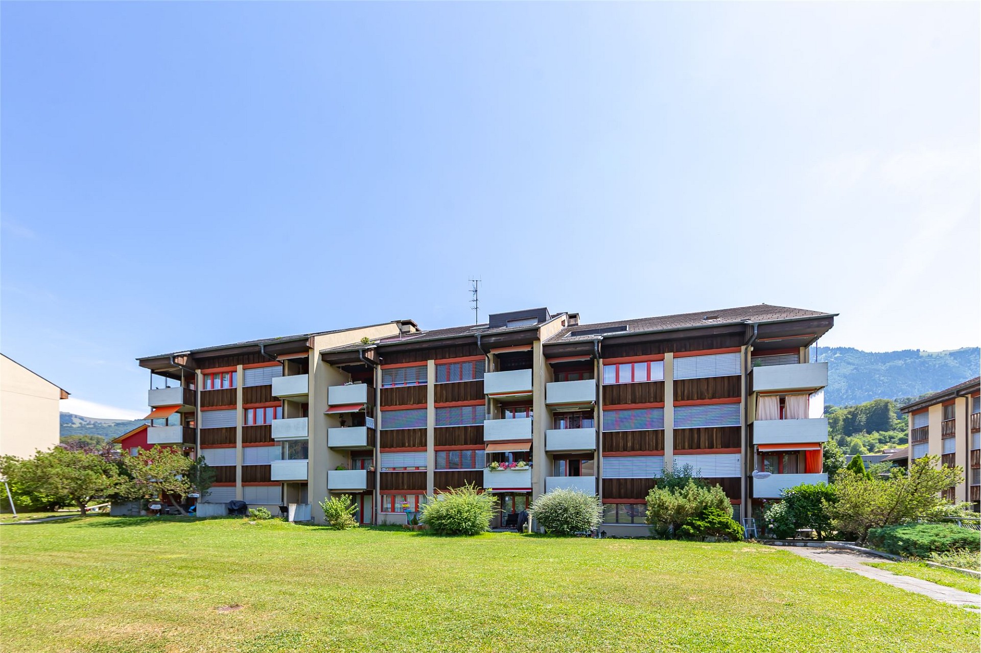 Mehrfamilienhaus mit Balkonfassade und Grünanlage