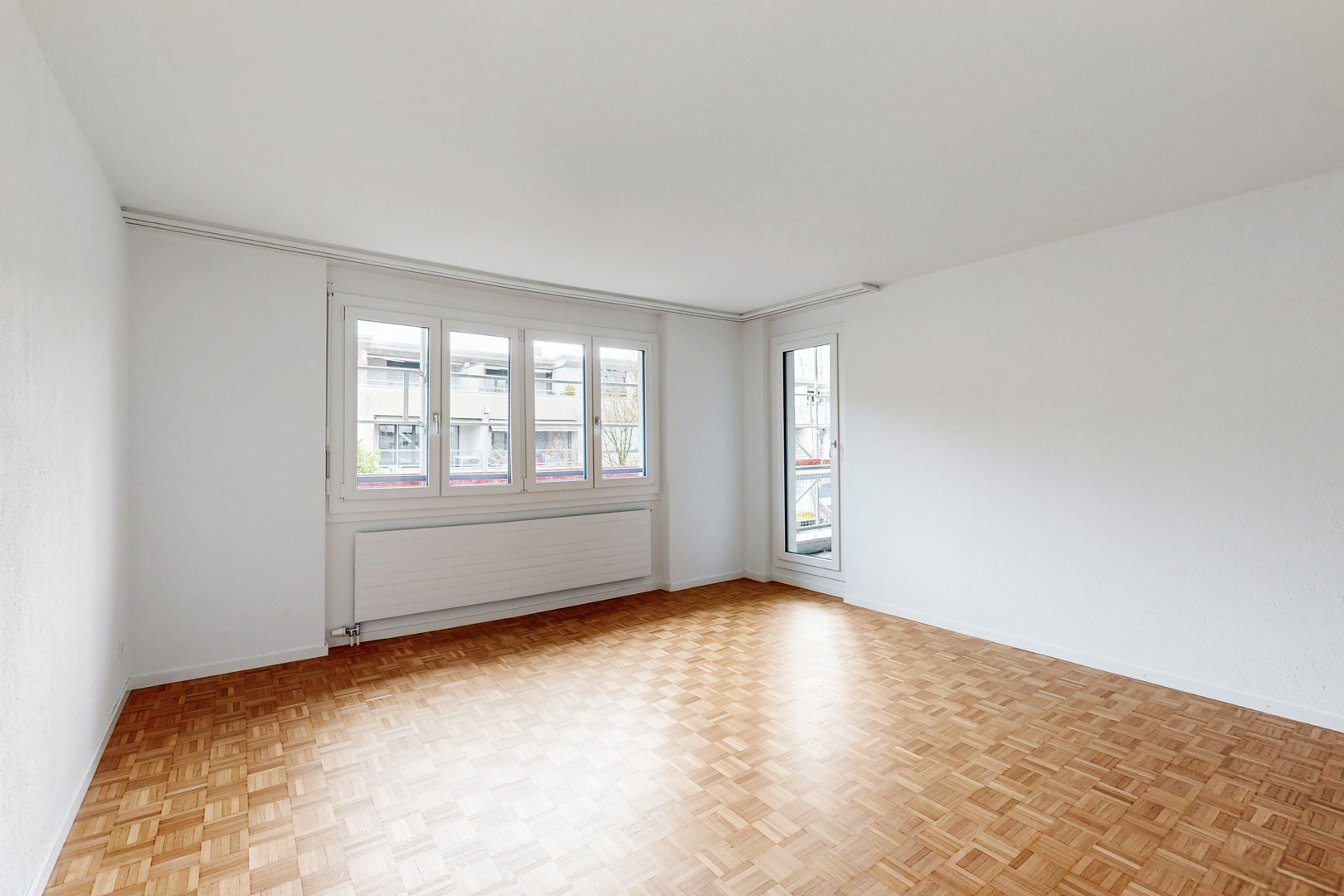 Helles, leer stehendes Zimmer mit Parkettboden