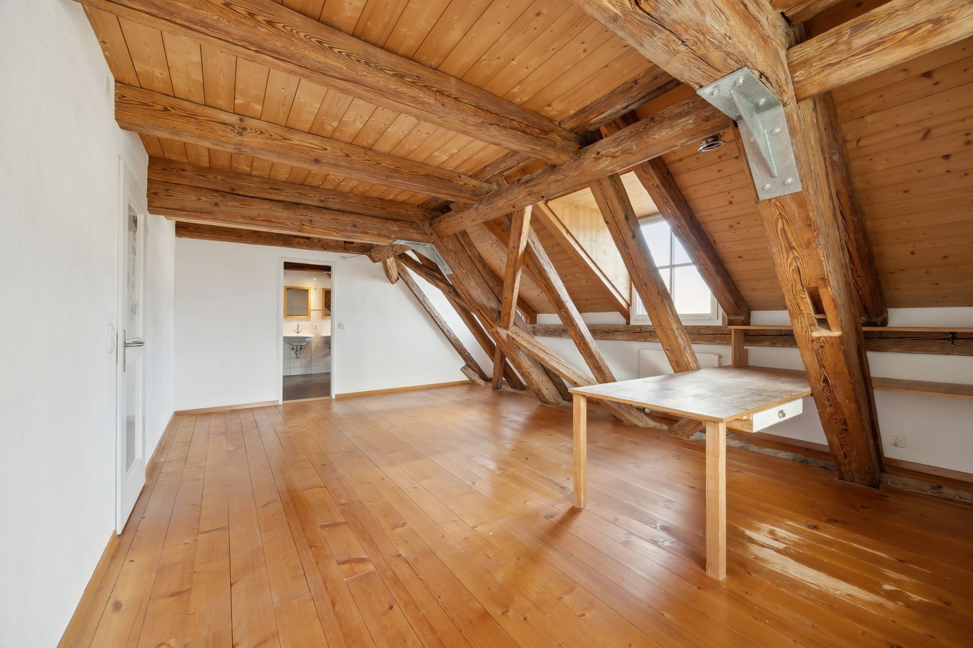 Dachgeschossraum mit sichtbaren Holzbalken