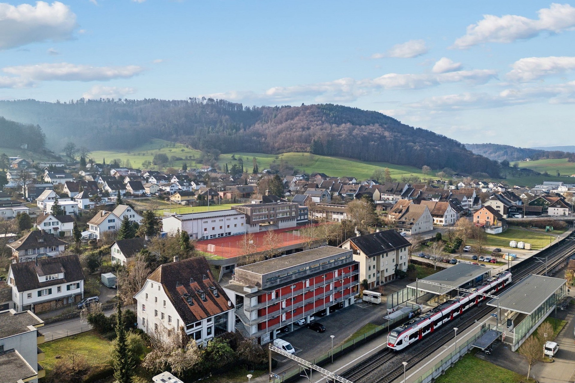 Luftaufnahme einer Kleinstadt mit Bahnstation