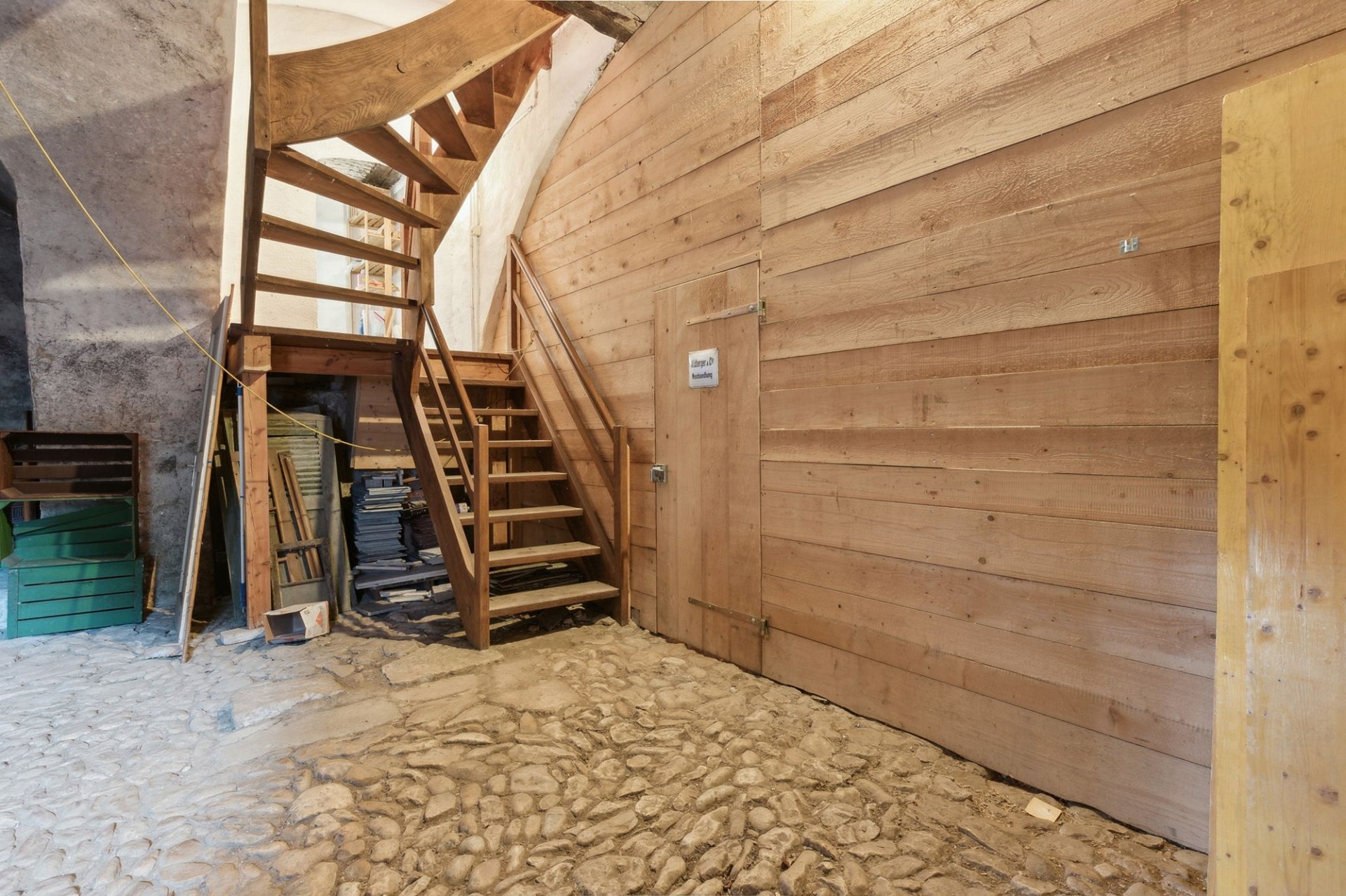 Rustikale Innenszene mit Holztreppe und Steinfußboden