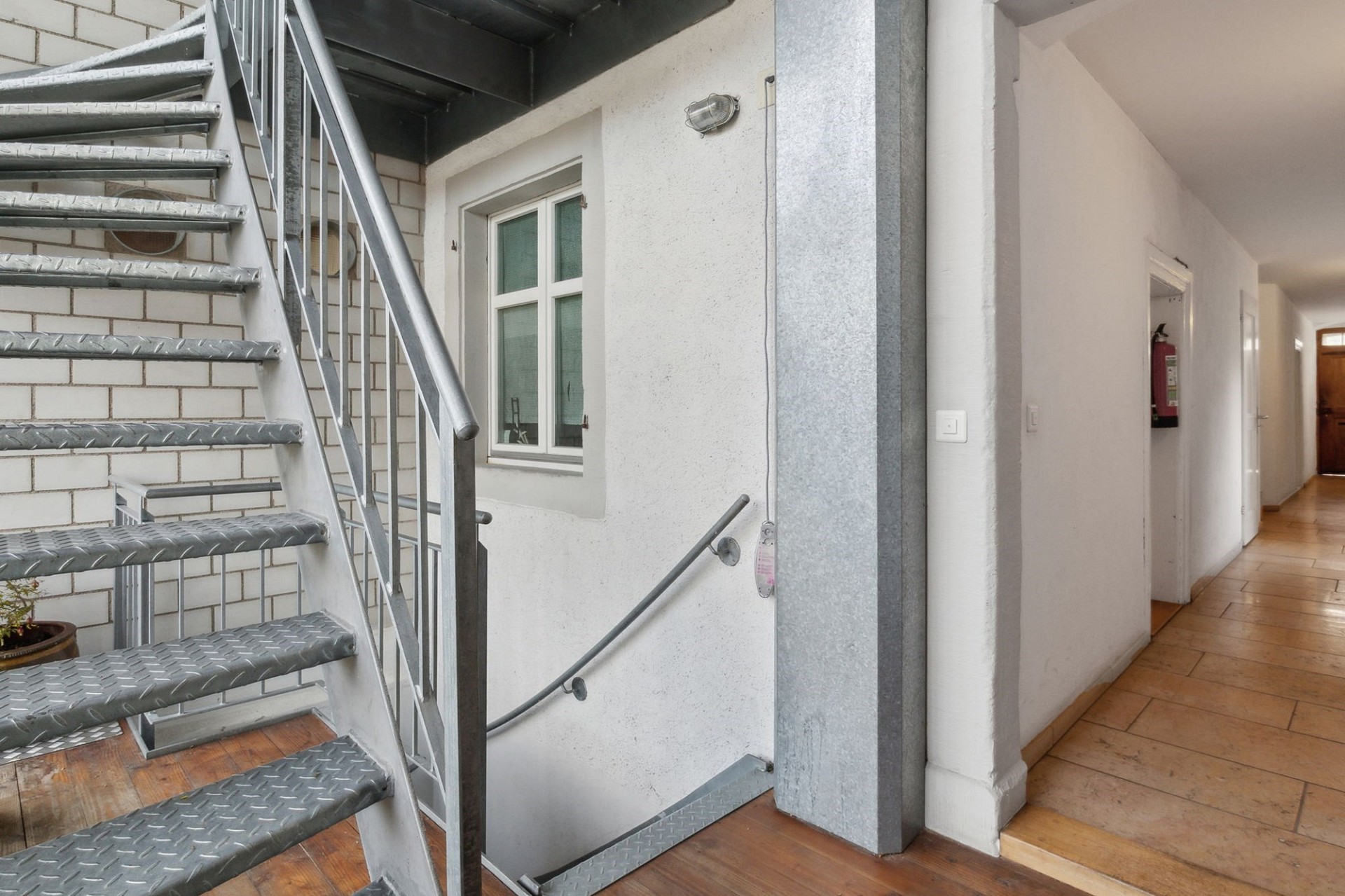 Treppenhaus mit Flur und Zugang zu einer Wohnung
