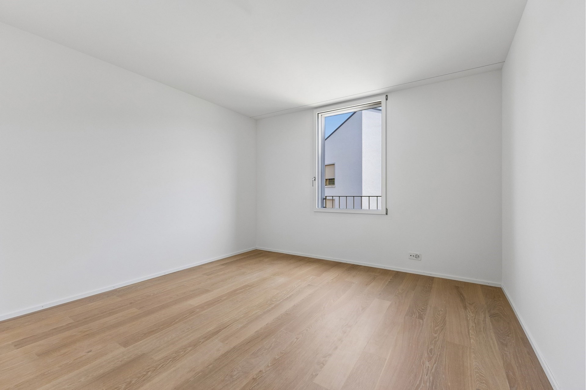 Helles leeres Zimmer mit Holzoptikboden