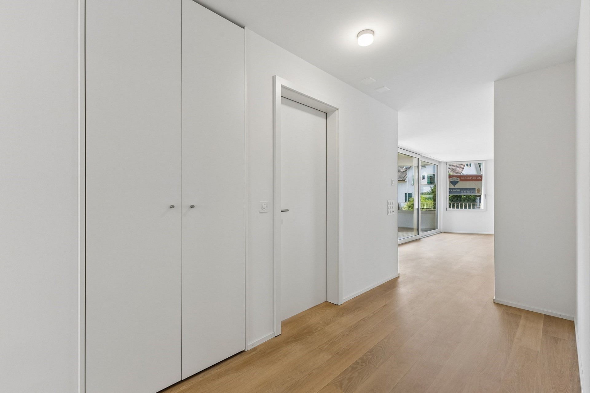 Heller Flur mit Einbauschrank und Balkonblick
