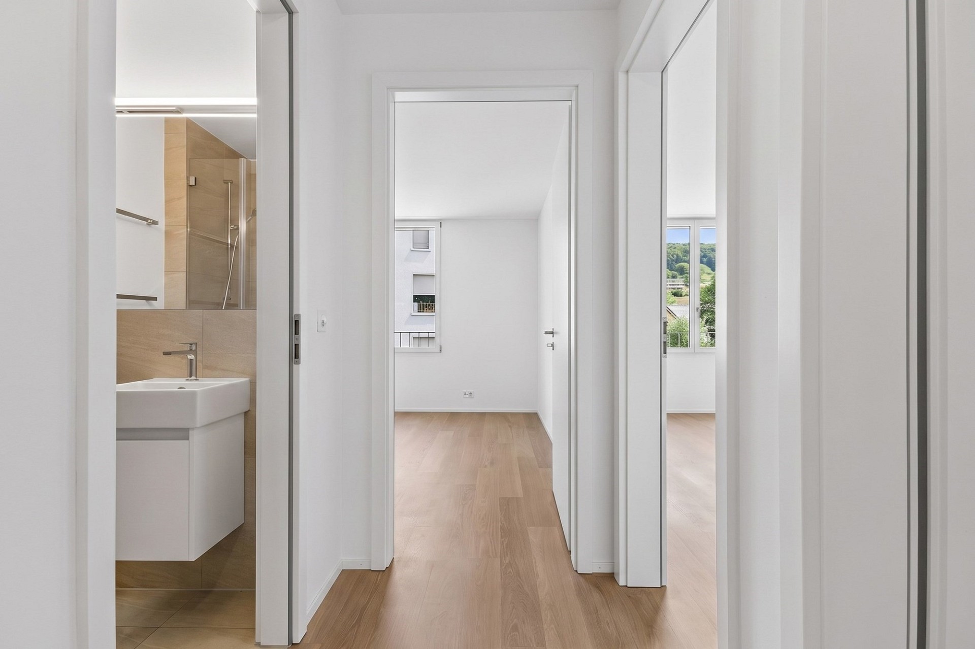 Heller Flur mit Blick ins Badezimmer und in angrenzende Zimmer
