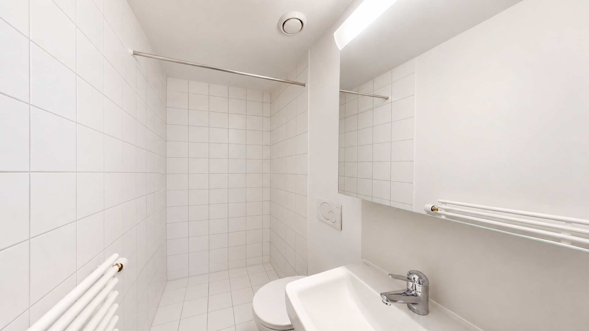 Kleines weißes Badezimmer mit Dusche und Waschbecken