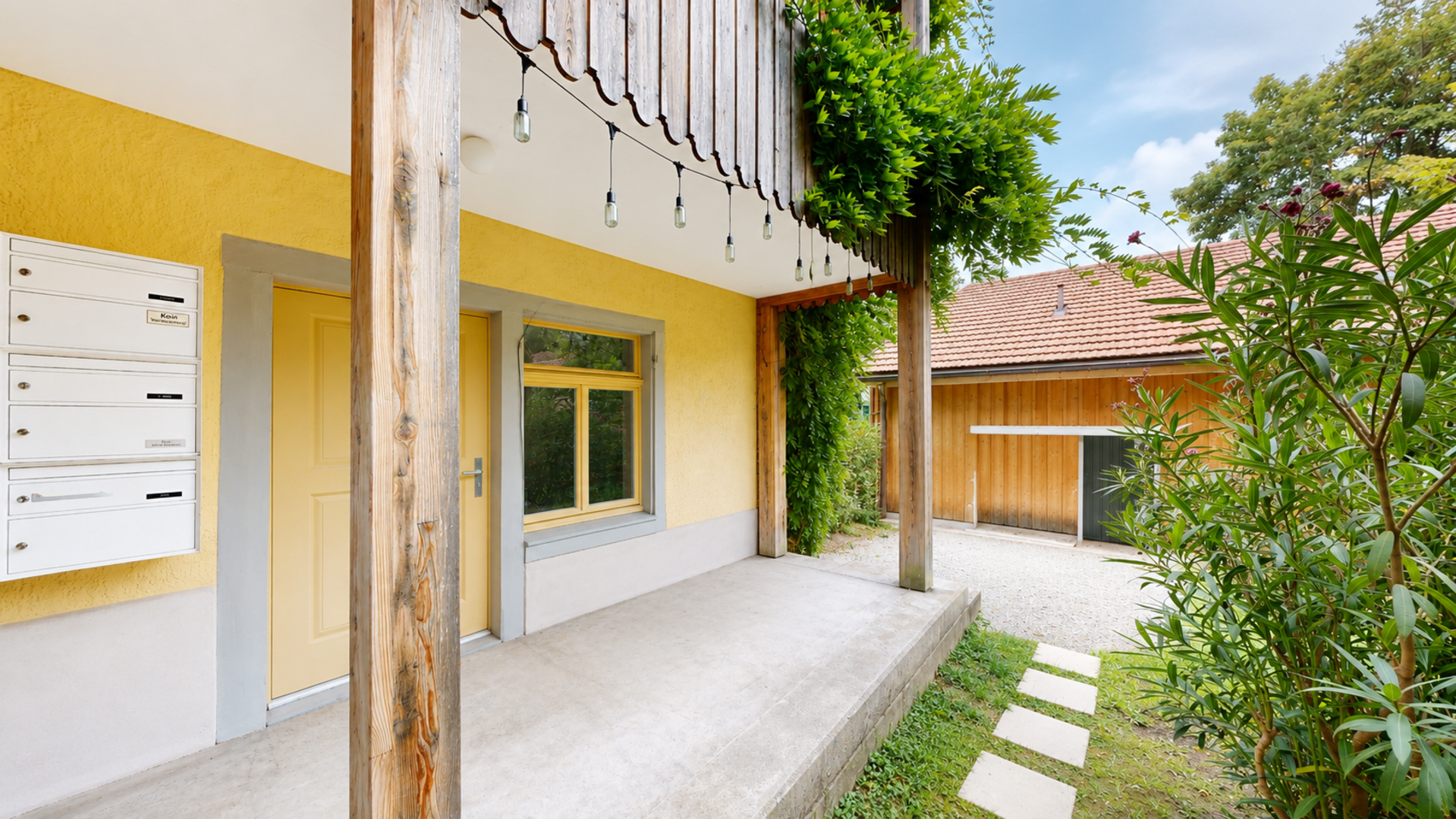 Außenbereich einer Wohnimmobilie mit Holzverkleidung und Veranda