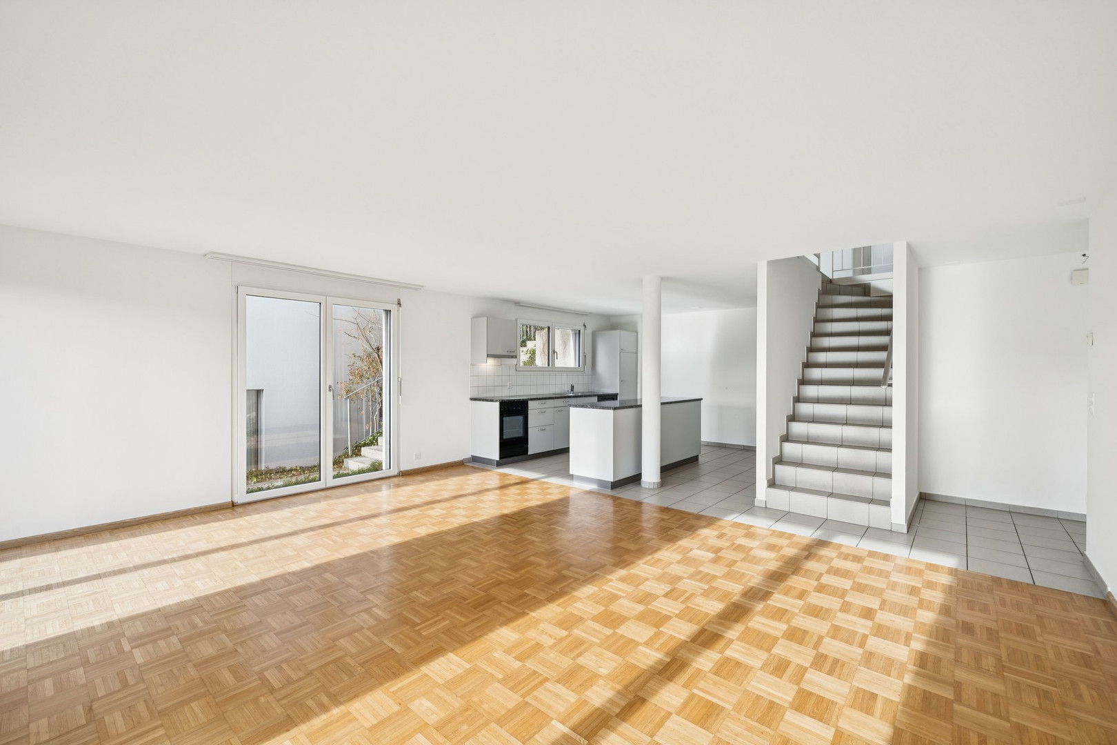 Offener Wohnbereich mit Küche und Treppe