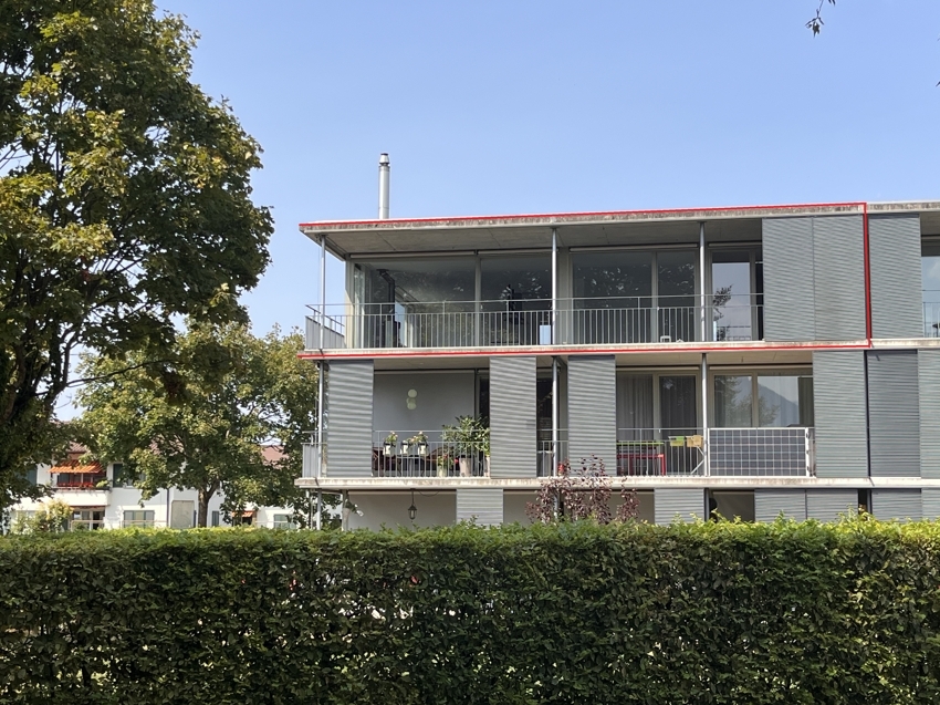 Mehrfamilienhaus mit Balkonen und Grünabgrenzung
