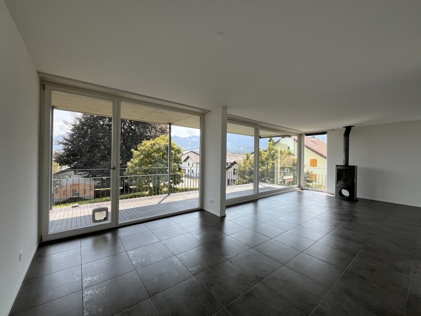Großer Wohnraum mit Panoramafenstern und Kamin