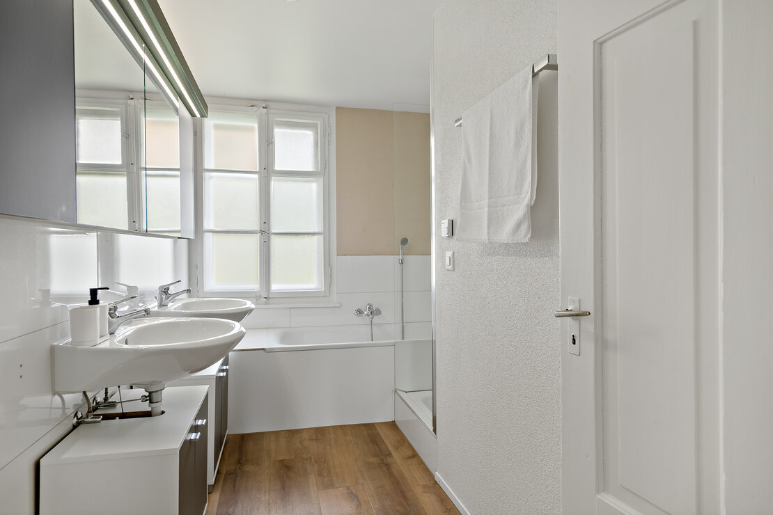 Helles Badezimmer mit Badewanne und Doppelwaschbecken
