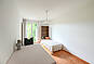 Helles Schlafzimmer mit Schreibtisch und Balkonblick