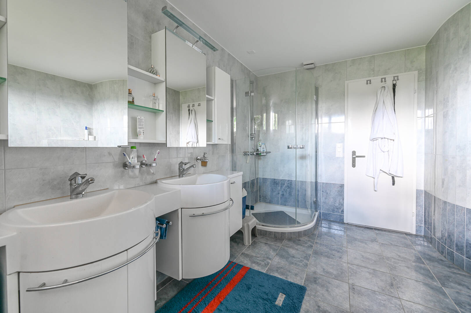 Modernes Badezimmer mit Doppelwaschtisch und Glasdusche