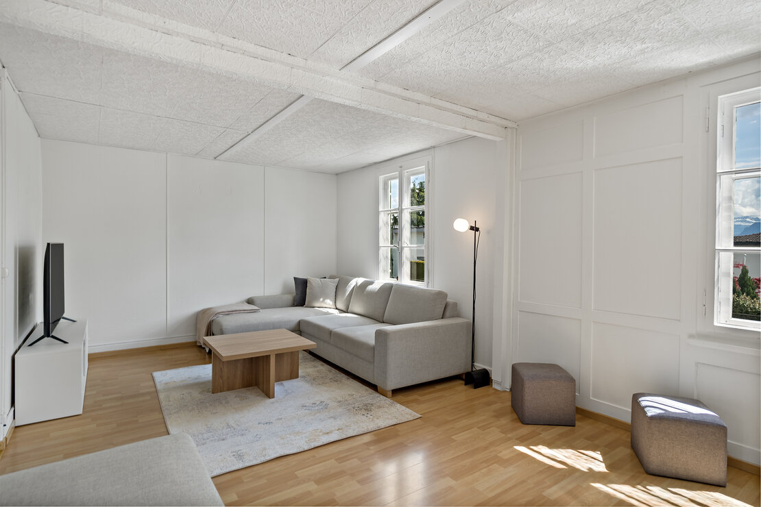 Helles, minimalistisches Wohnzimmer mit Sofa und Tageslicht