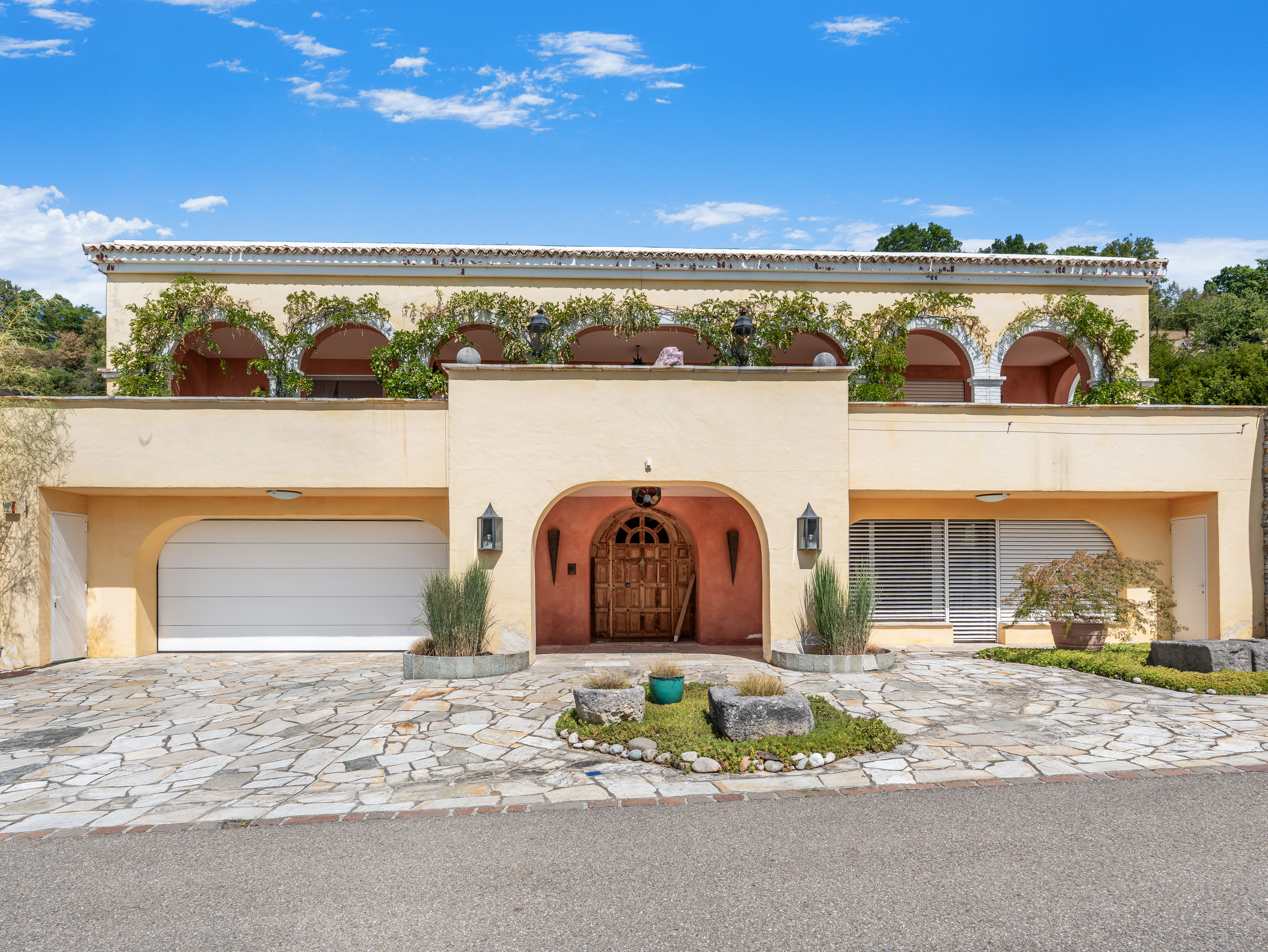 Mediterrane Villenfassade mit Arkaden und Innenhofzufahrt