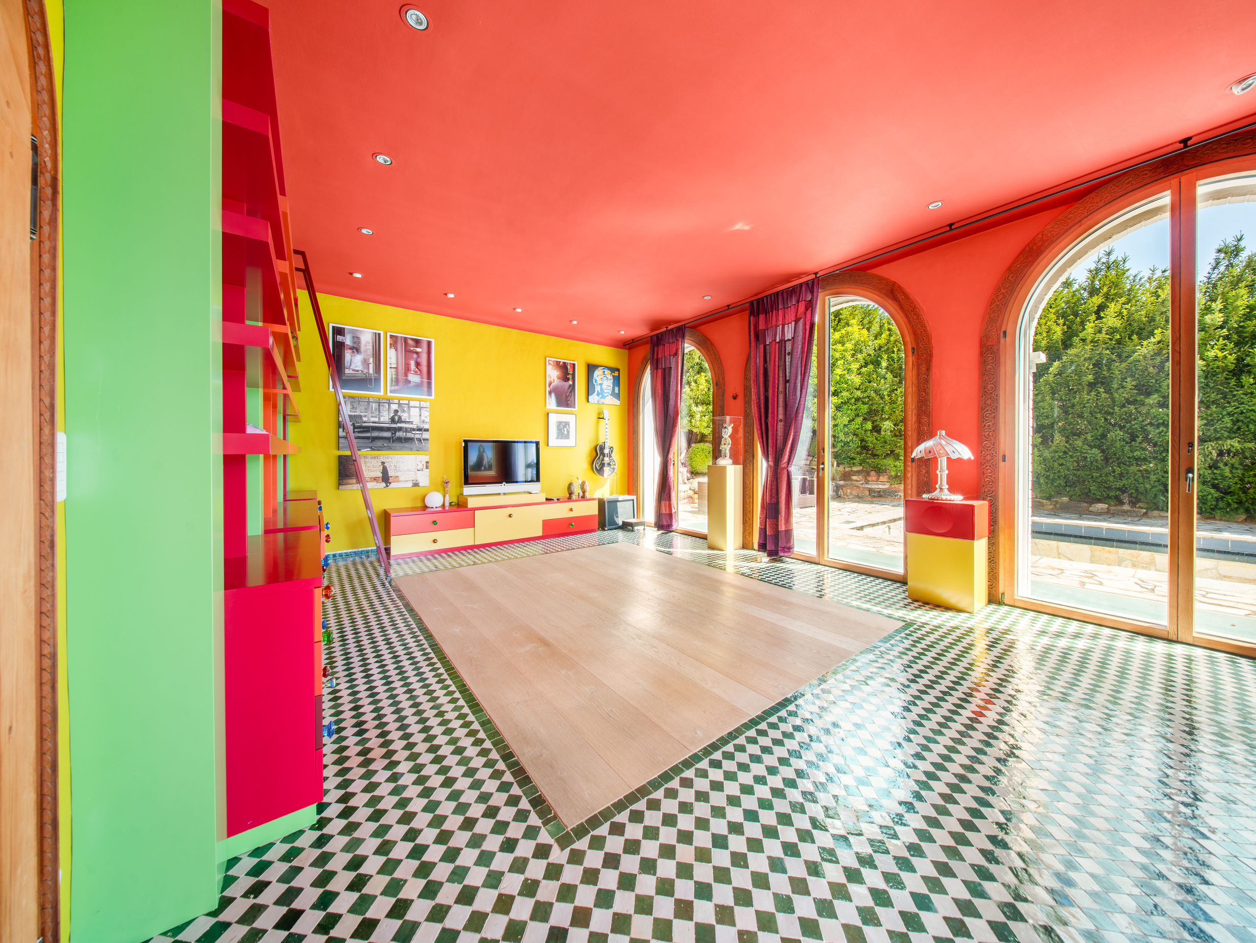 Buntes Wohnzimmer mit großen Rundbogenfenstern