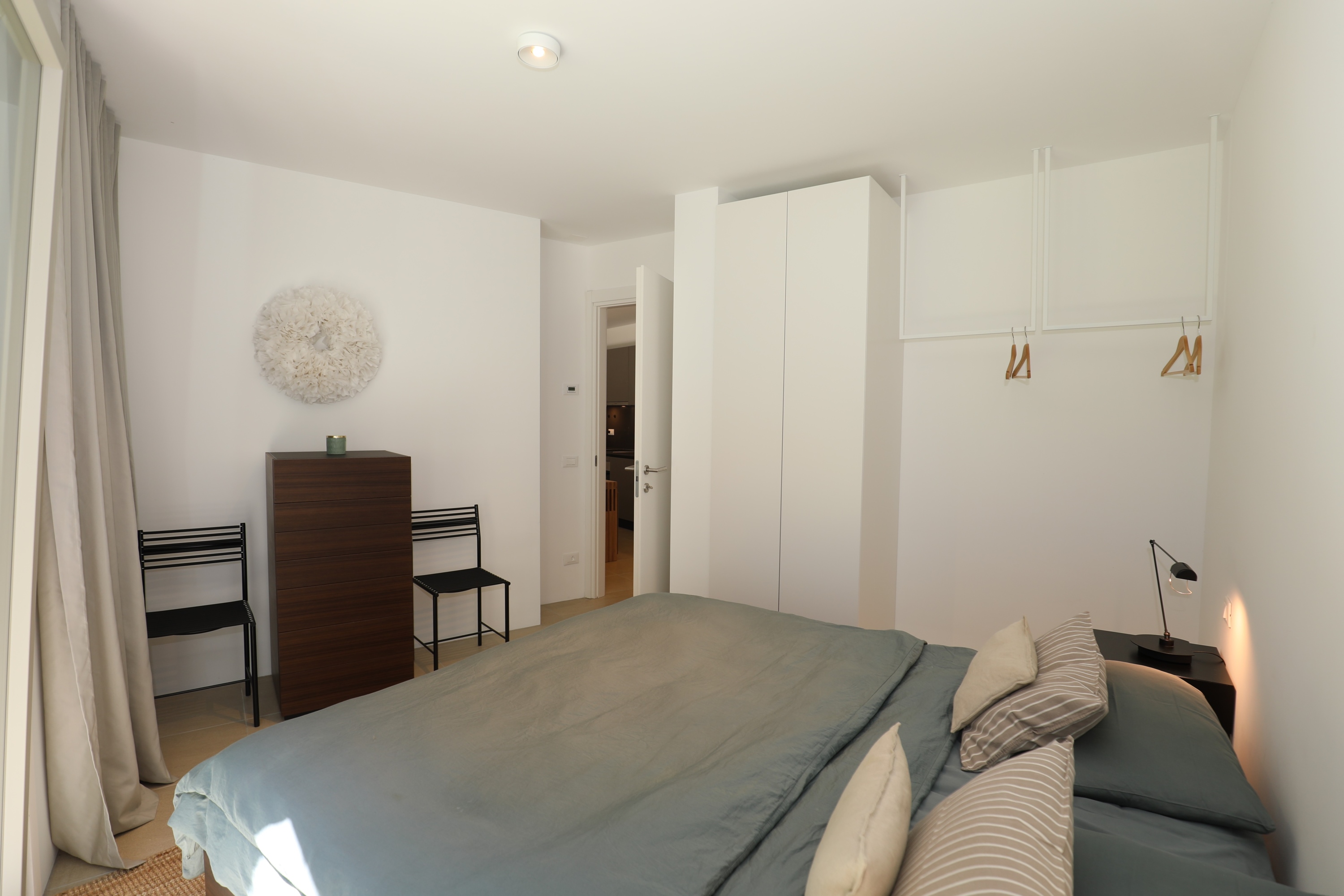 Helles, minimalistisches Schlafzimmer mit Doppelbett und Kleiderschränken