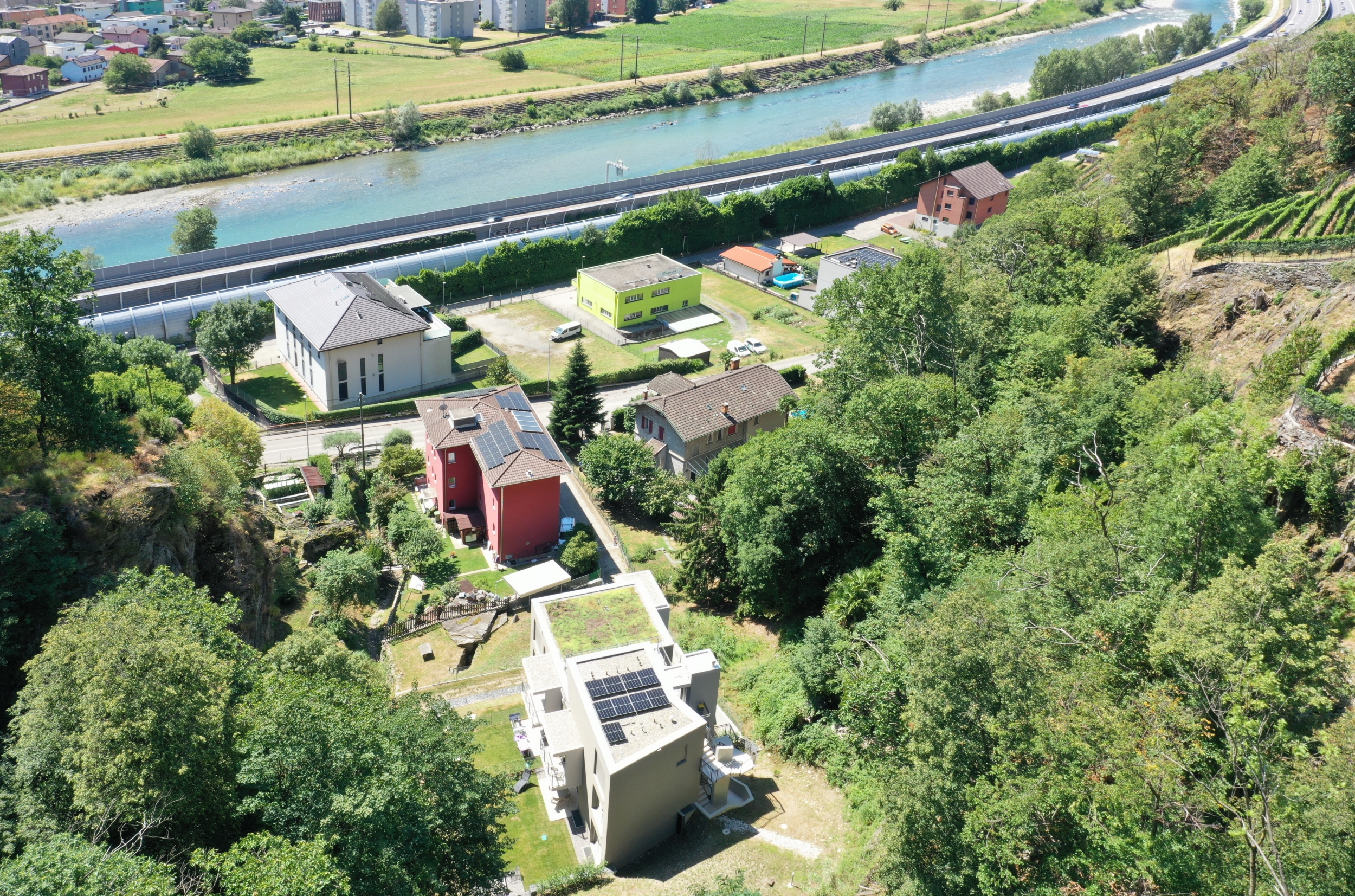 Luftaufnahme eines hangseitigen Wohngebiets am Fluss