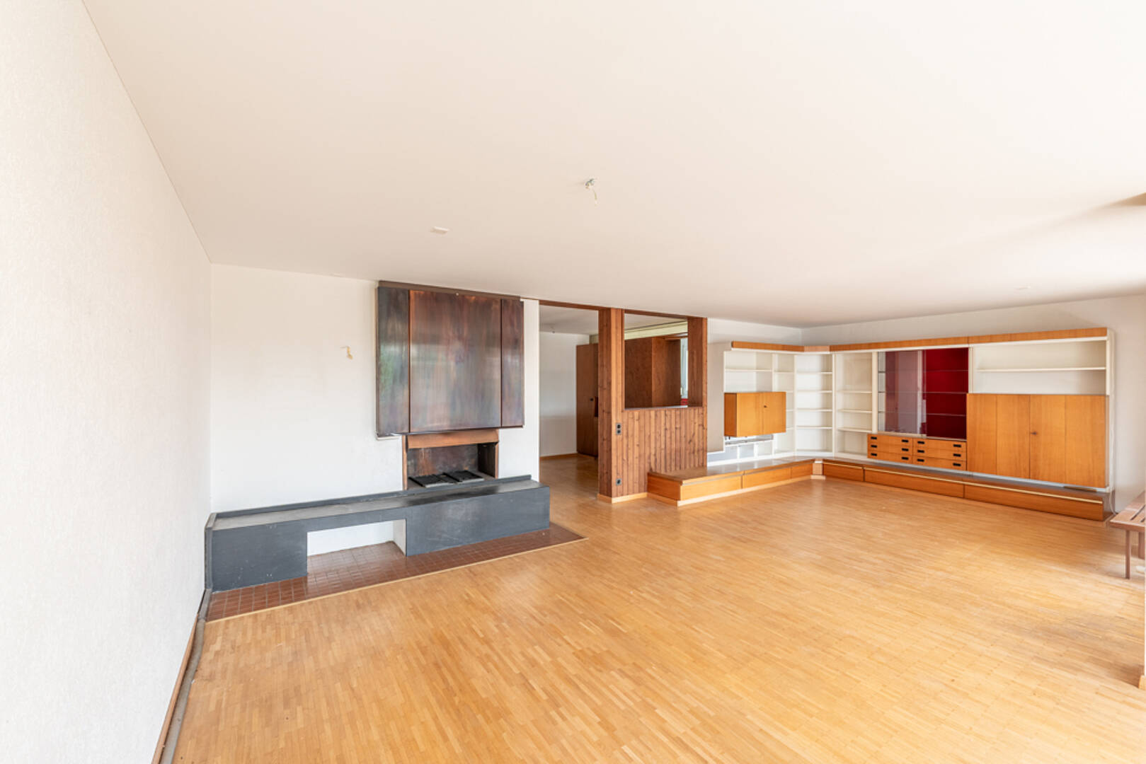 Großzügiges Wohnzimmer mit Kaminwand und Einbauten