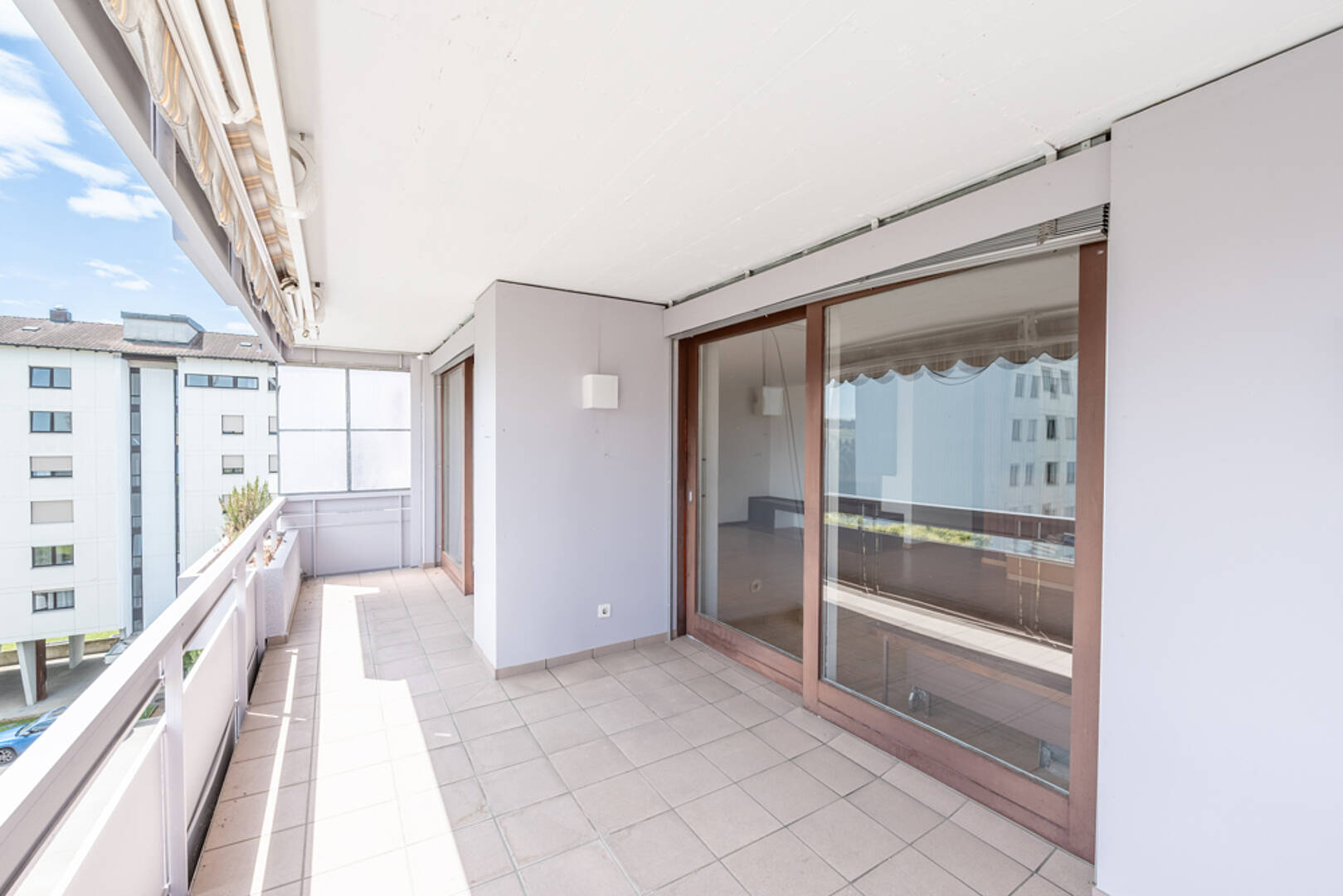Großer überdachter Balkon mit Schiebetüren