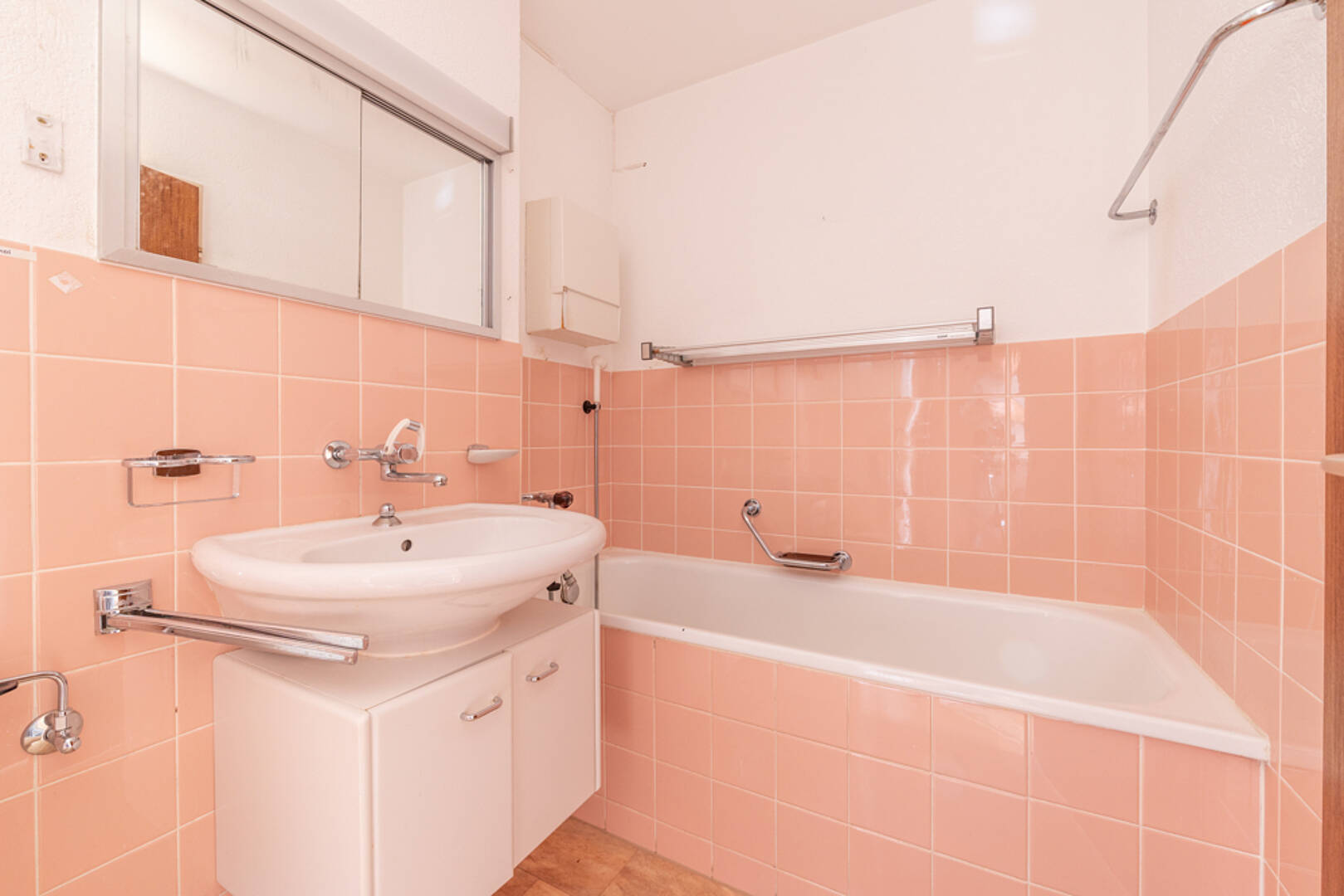 Badezimmer mit rosafarbenen Fliesen und Badewanne
