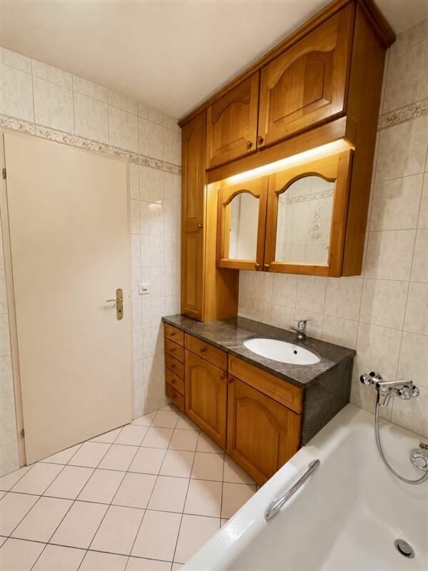 Badezimmer mit Holzschrank und Badewanne