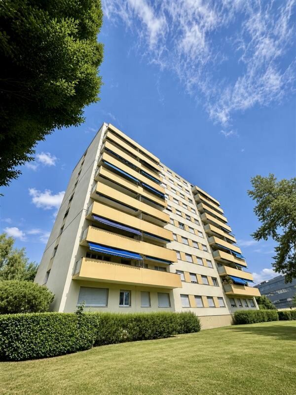 Wohnhochhaus mit Balkonen und Grünanlage