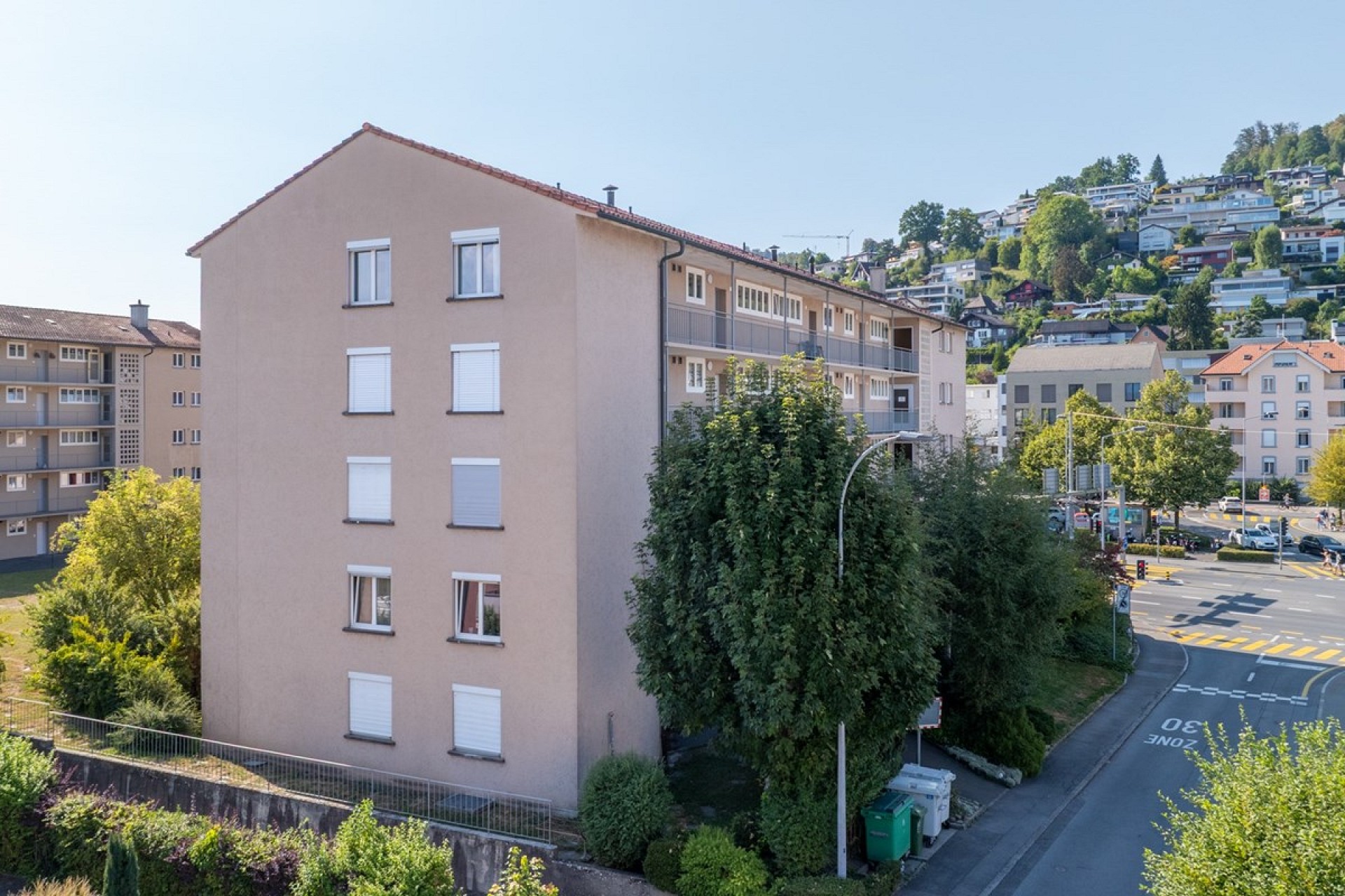 Mehrfamilienhaus mit Blick auf städtische Hanglage