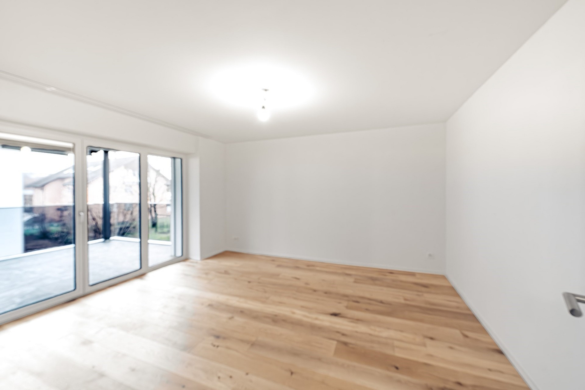 Heller leerer Wohnraum mit Balkonzugang