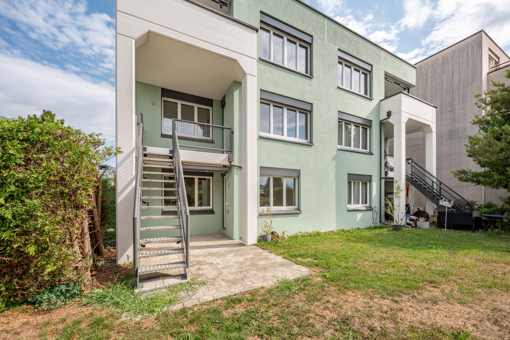 Mehrfamilienhaus mit Außentreppe und Garten