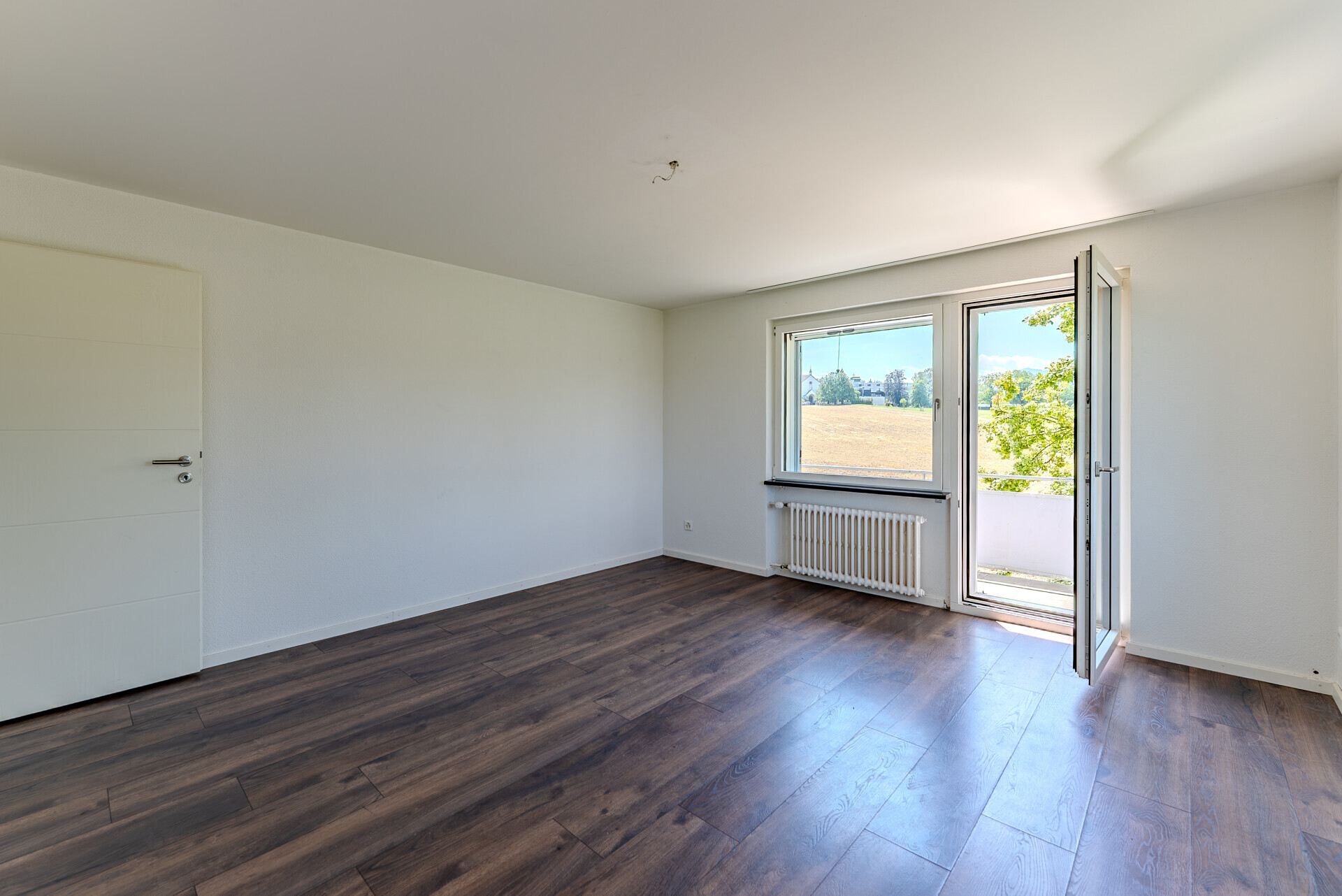 Heller leerer Raum mit Balkon und Ausblick