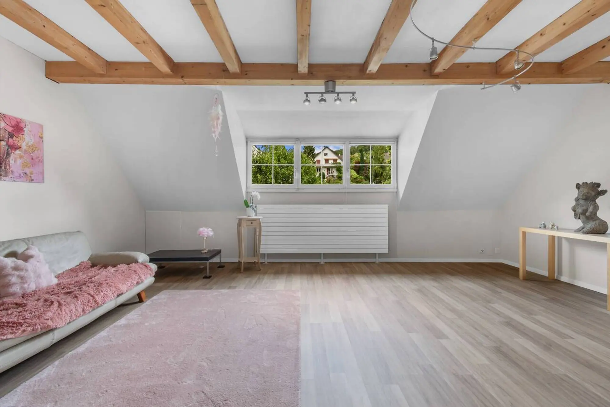 Heller Dachgeschoss-Wohnraum mit sichtbaren Holzbalken