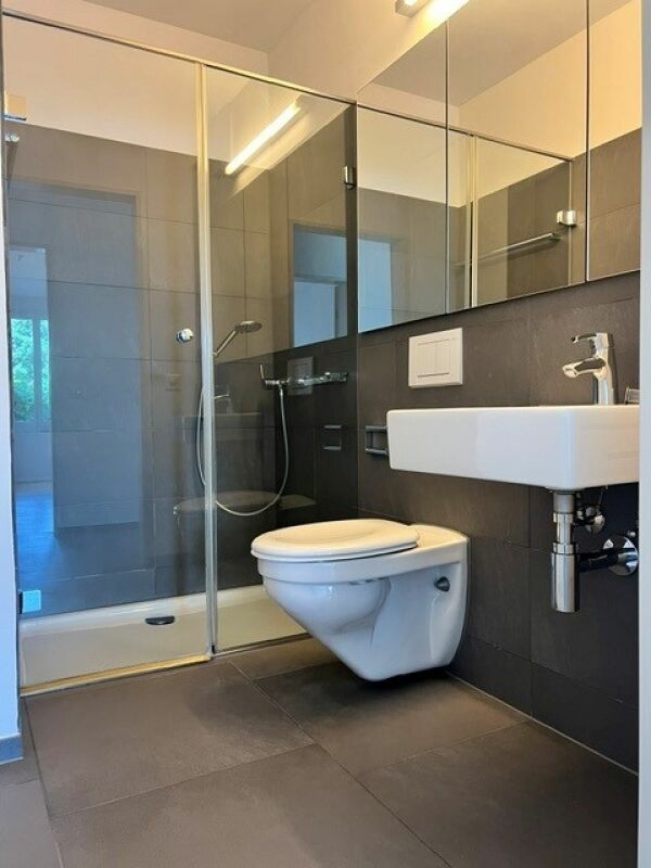 Modernes Badezimmer mit Glasdusche und wandhängendem WC